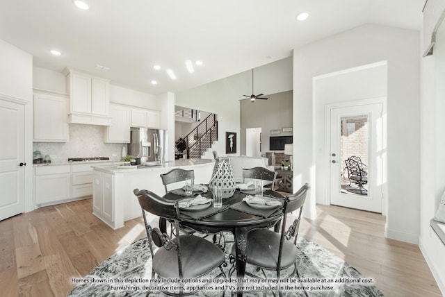 dining area with lofted ceiling, ceiling fan, and light hardwood / wood-style flooring