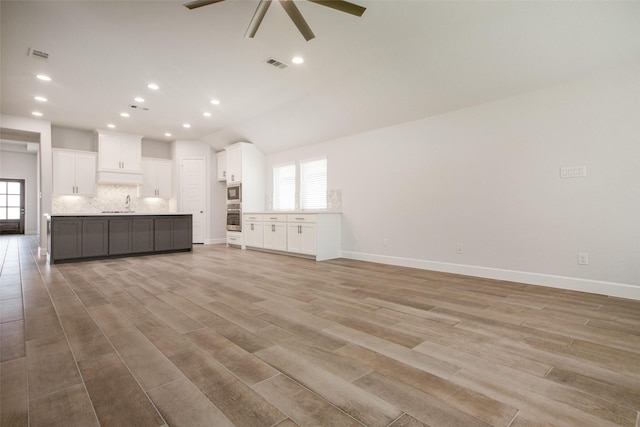 unfurnished living room with ceiling fan, light hardwood / wood-style floors, and sink