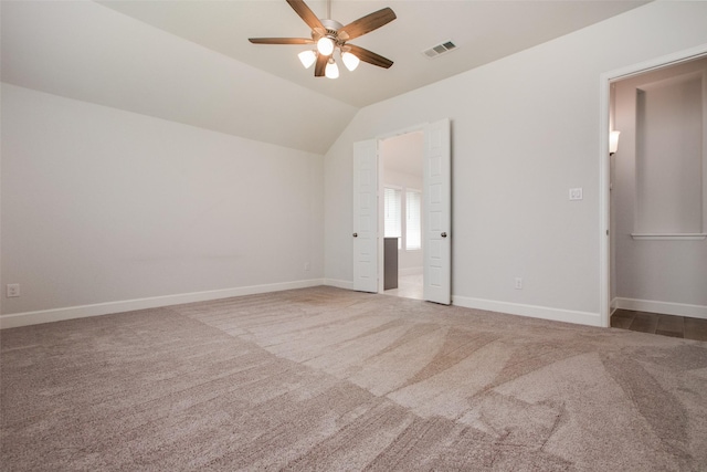 unfurnished bedroom with ceiling fan, lofted ceiling, and carpet