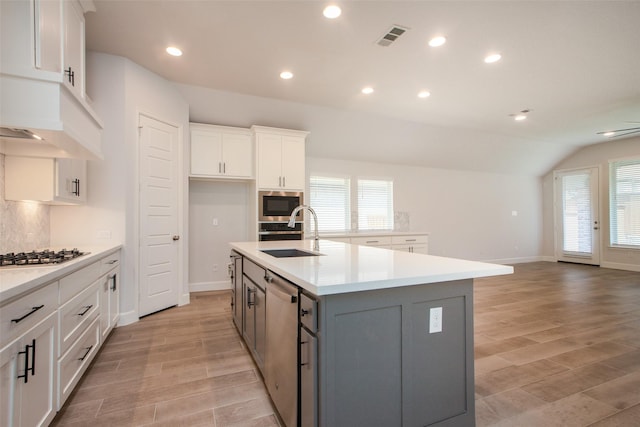 kitchen featuring sink, a center island with sink, white cabinets, and gray cabinetry