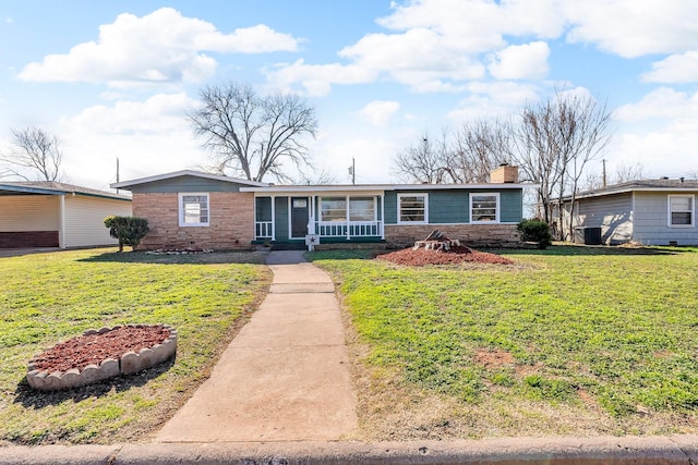 single story home with covered porch and a front lawn