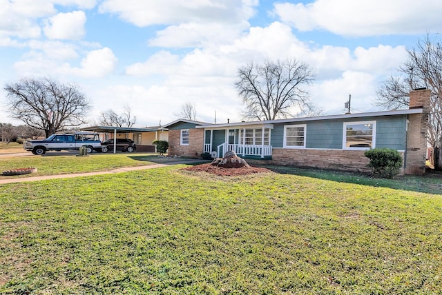 single story home with a porch, a front yard, and a carport