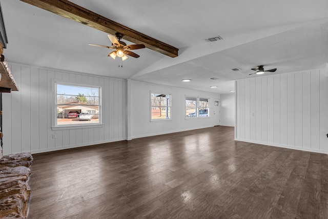 unfurnished living room featuring ceiling fan, a healthy amount of sunlight, vaulted ceiling with beams, and dark hardwood / wood-style floors