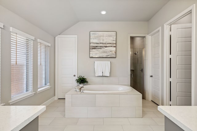 bathroom with independent shower and bath, vaulted ceiling, a wealth of natural light, and vanity