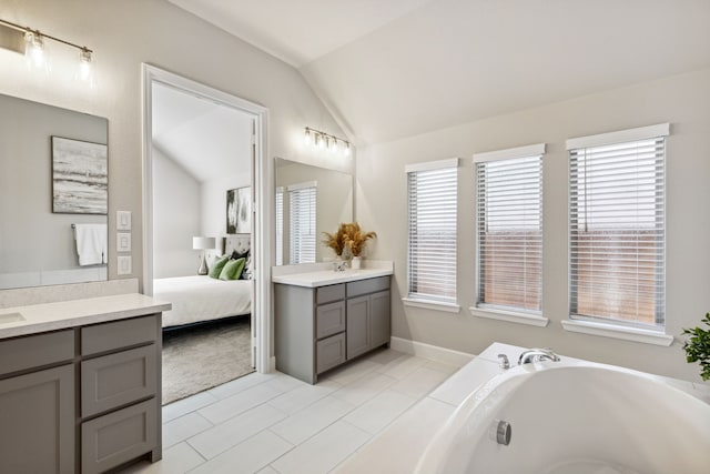 bathroom with lofted ceiling, tile patterned flooring, a healthy amount of sunlight, and vanity