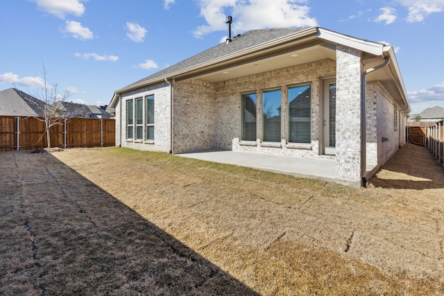 back of house with a yard and a patio