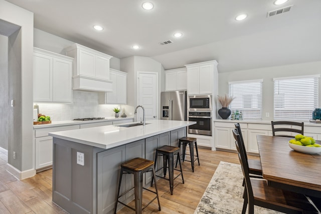 kitchen featuring sink, white cabinetry, an island with sink, and appliances with stainless steel finishes