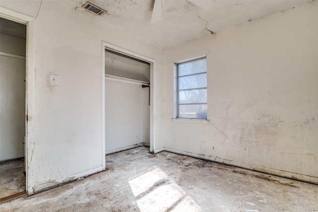 unfurnished bedroom featuring ceiling fan and a closet