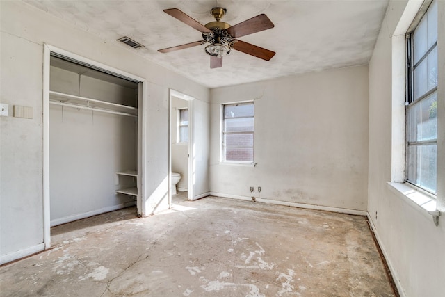 unfurnished bedroom featuring ensuite bathroom, ceiling fan, and a closet