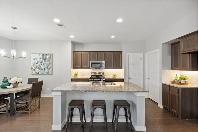 kitchen with stainless steel appliances, light stone countertops, and tasteful backsplash