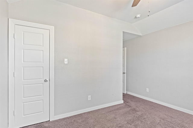 carpeted empty room with ceiling fan and vaulted ceiling