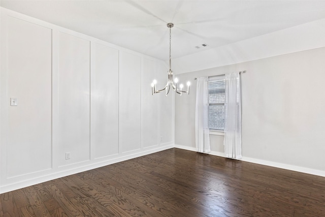 unfurnished room with a chandelier and hardwood / wood-style flooring