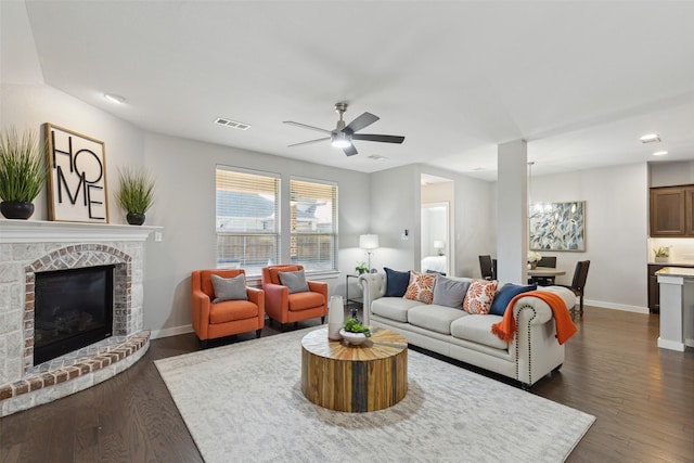 living room featuring ceiling fan, dark wood-type flooring, and a fireplace