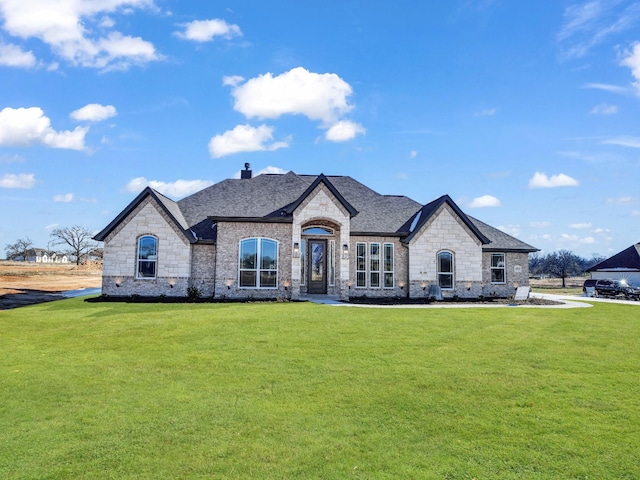 french country home featuring a front lawn