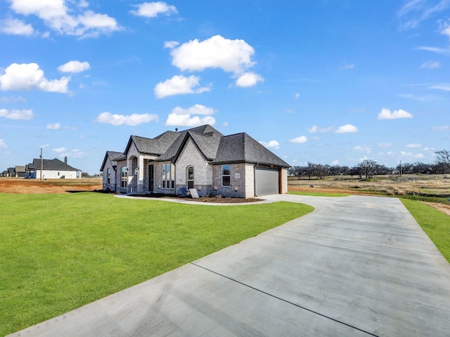 french provincial home with a front yard and a garage