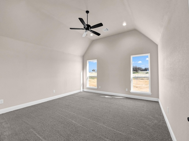 carpeted empty room featuring lofted ceiling, ceiling fan, and a wealth of natural light