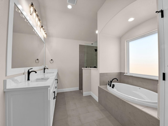 bathroom with tile patterned flooring, independent shower and bath, and vanity