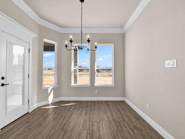 unfurnished dining area featuring dark wood-type flooring, an inviting chandelier, and crown molding