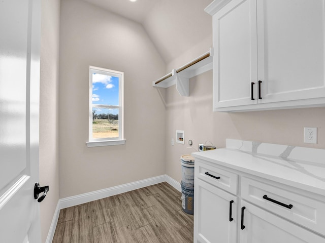 laundry area featuring washer hookup, cabinets, and light hardwood / wood-style floors