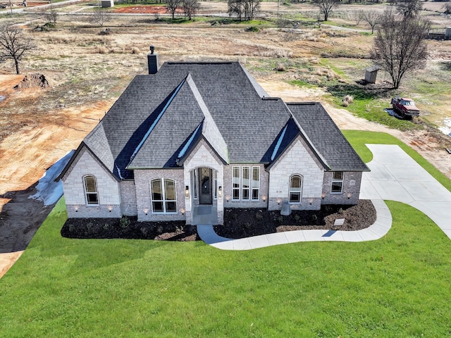 french country home featuring a front yard