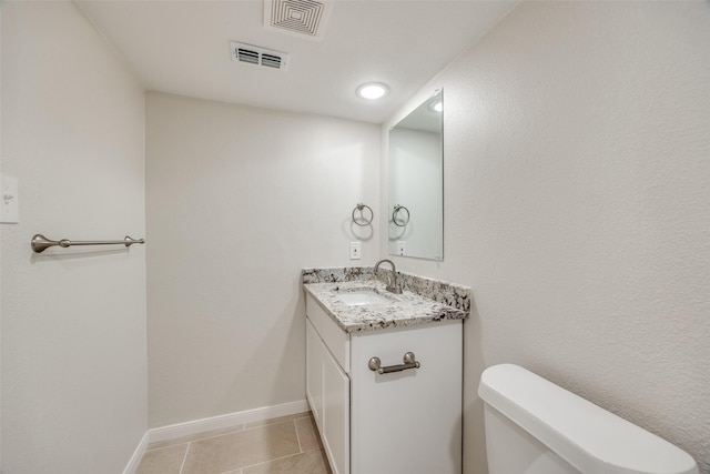 bathroom featuring tile patterned flooring, vanity, and toilet