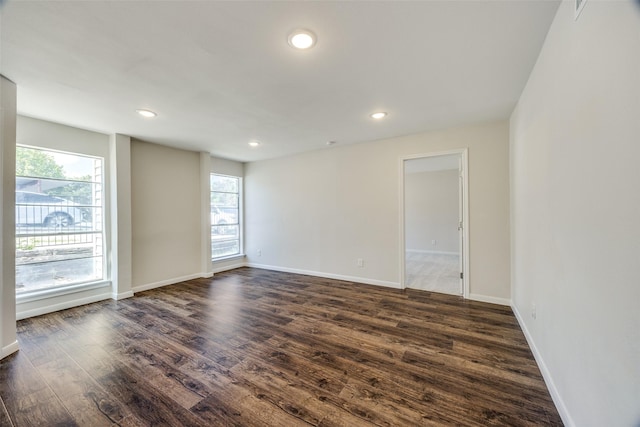 empty room with dark hardwood / wood-style flooring