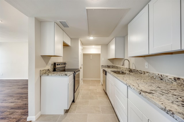 kitchen with stainless steel appliances, white cabinetry, sink, and light stone counters