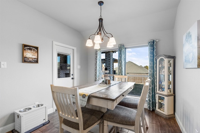 dining area featuring a notable chandelier, dark hardwood / wood-style flooring, and lofted ceiling