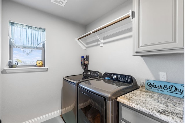 washroom with washer and dryer and cabinets