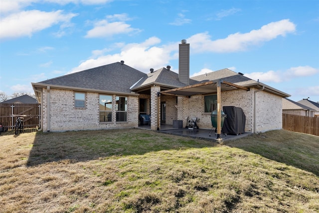 rear view of house with a patio area and a lawn