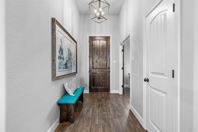 corridor with a notable chandelier and dark hardwood / wood-style floors