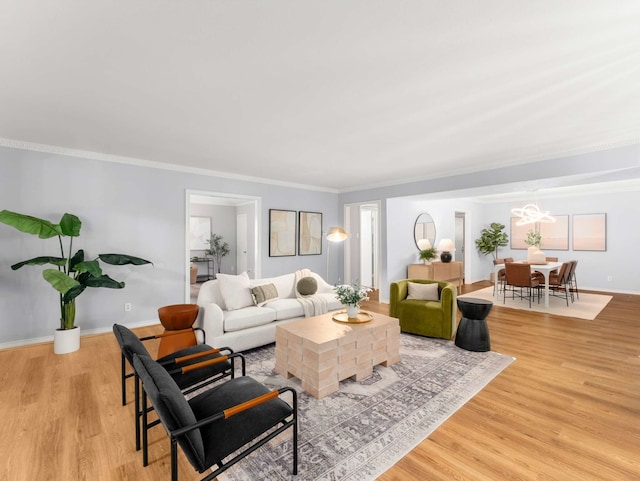 living room featuring a chandelier, ornamental molding, baseboards, and wood finished floors