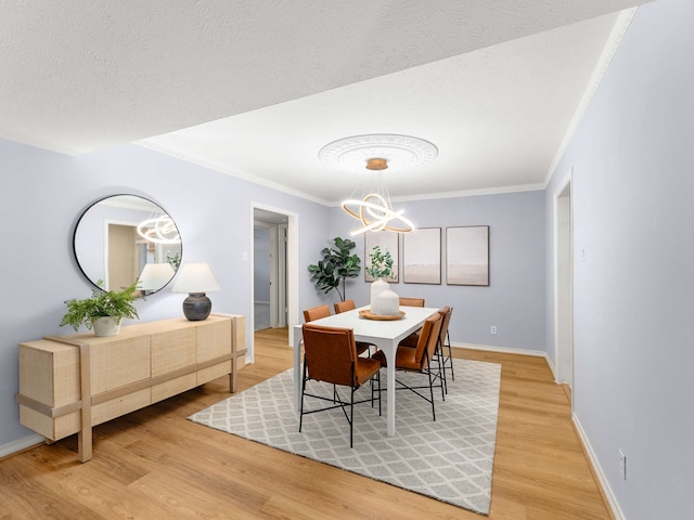 dining space featuring ornamental molding, an inviting chandelier, a textured ceiling, and hardwood / wood-style flooring