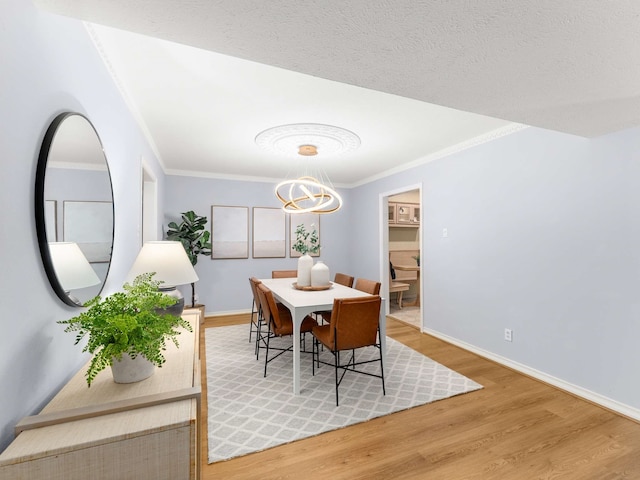 dining room featuring ornamental molding, an inviting chandelier, a textured ceiling, and wood-type flooring