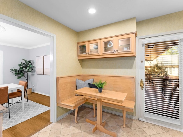 dining area with light hardwood / wood-style floors, ornamental molding, and breakfast area