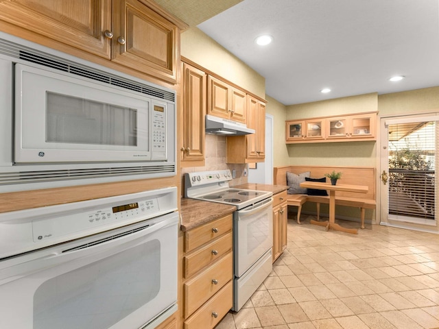 kitchen featuring white appliances, light tile patterned floors, and light brown cabinets