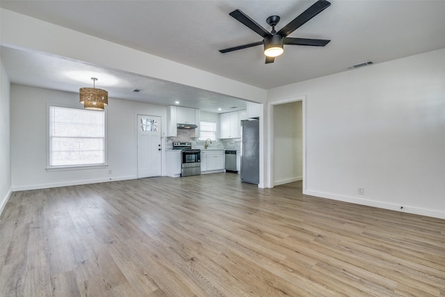 unfurnished living room featuring ceiling fan and light hardwood / wood-style floors