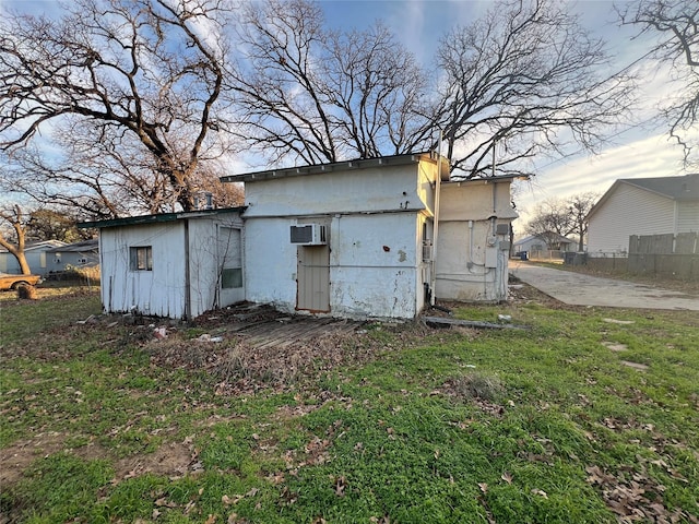 view of outbuilding with a wall mounted AC and a yard