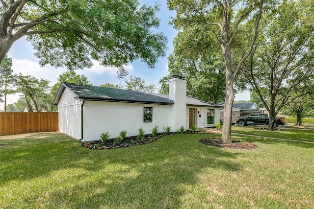 rear view of house featuring a lawn