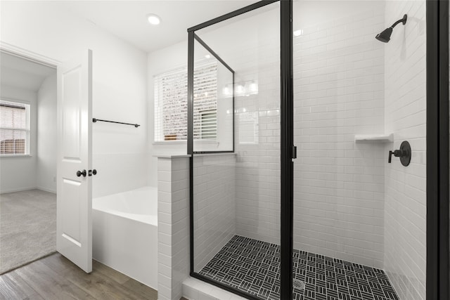 bathroom featuring hardwood / wood-style floors and independent shower and bath