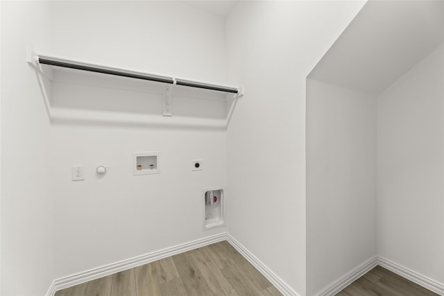 clothes washing area featuring hardwood / wood-style flooring, washer hookup, hookup for an electric dryer, and hookup for a gas dryer