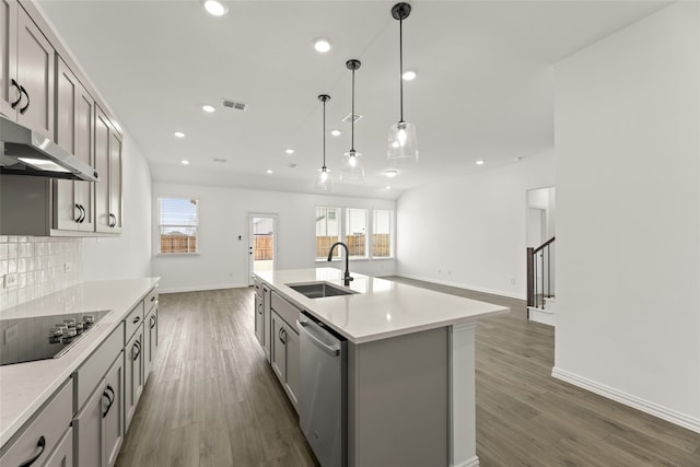 kitchen with sink, dishwasher, gray cabinetry, a kitchen island with sink, and black electric stovetop