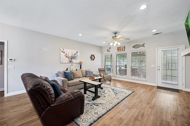 living room with wood-type flooring, a textured ceiling, and ceiling fan