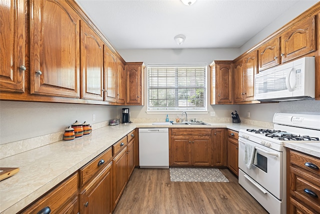 kitchen featuring dark wood-type flooring, sink, and white appliances