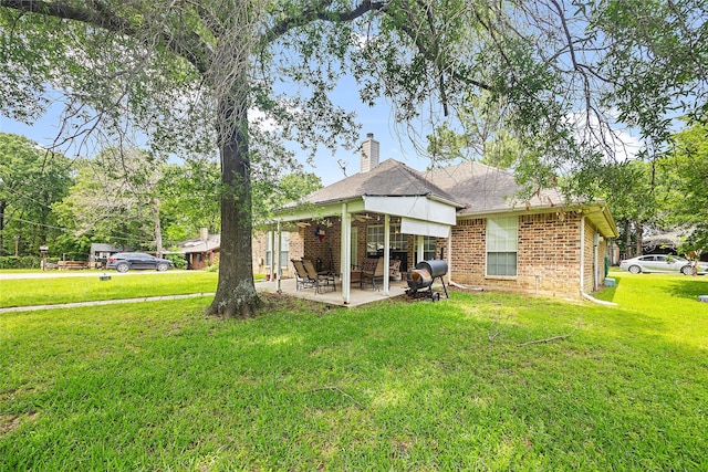 rear view of property with a patio and a yard