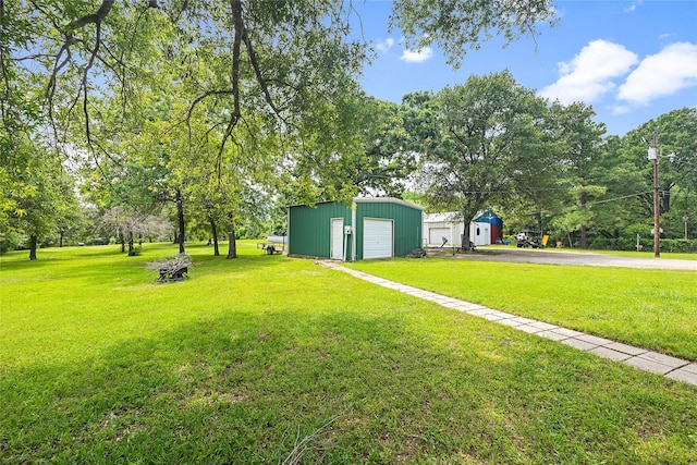 view of yard with a garage and an outbuilding