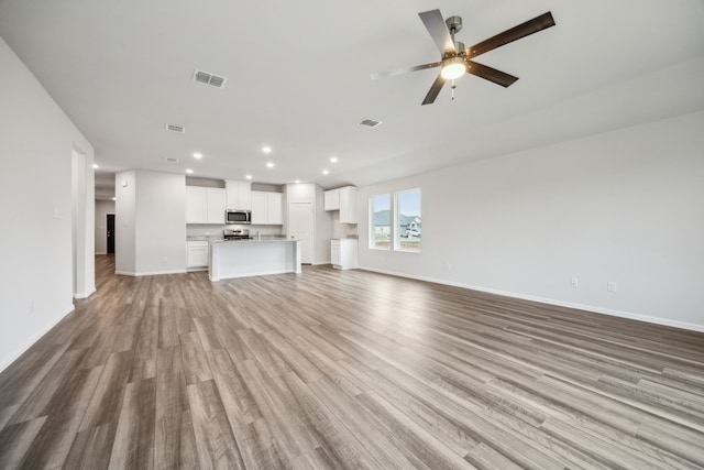 unfurnished living room with ceiling fan and light hardwood / wood-style flooring