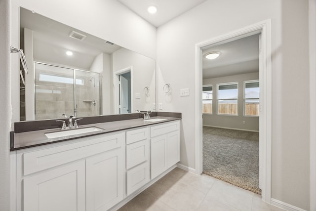 bathroom featuring vanity, tile patterned flooring, and a shower with door