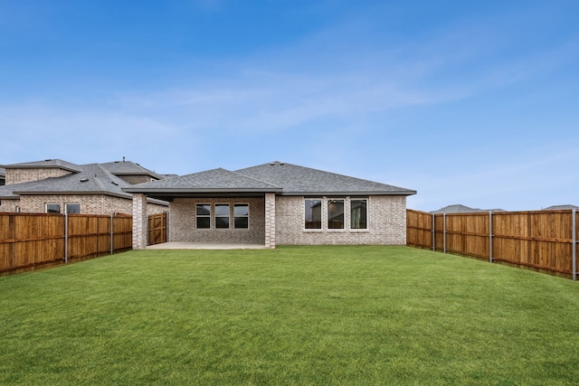 rear view of property featuring a yard and a patio