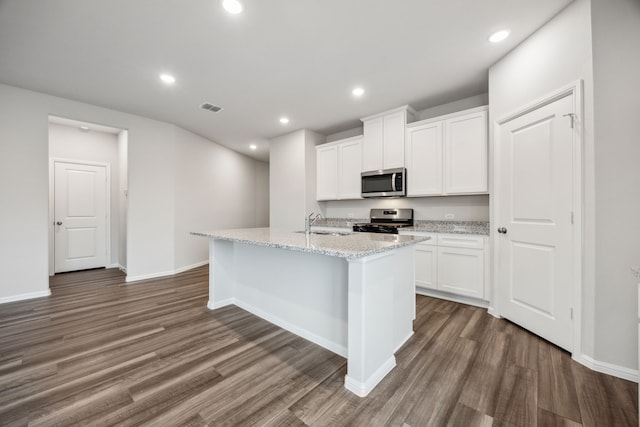 kitchen with a kitchen island with sink, dark hardwood / wood-style flooring, white cabinets, and appliances with stainless steel finishes